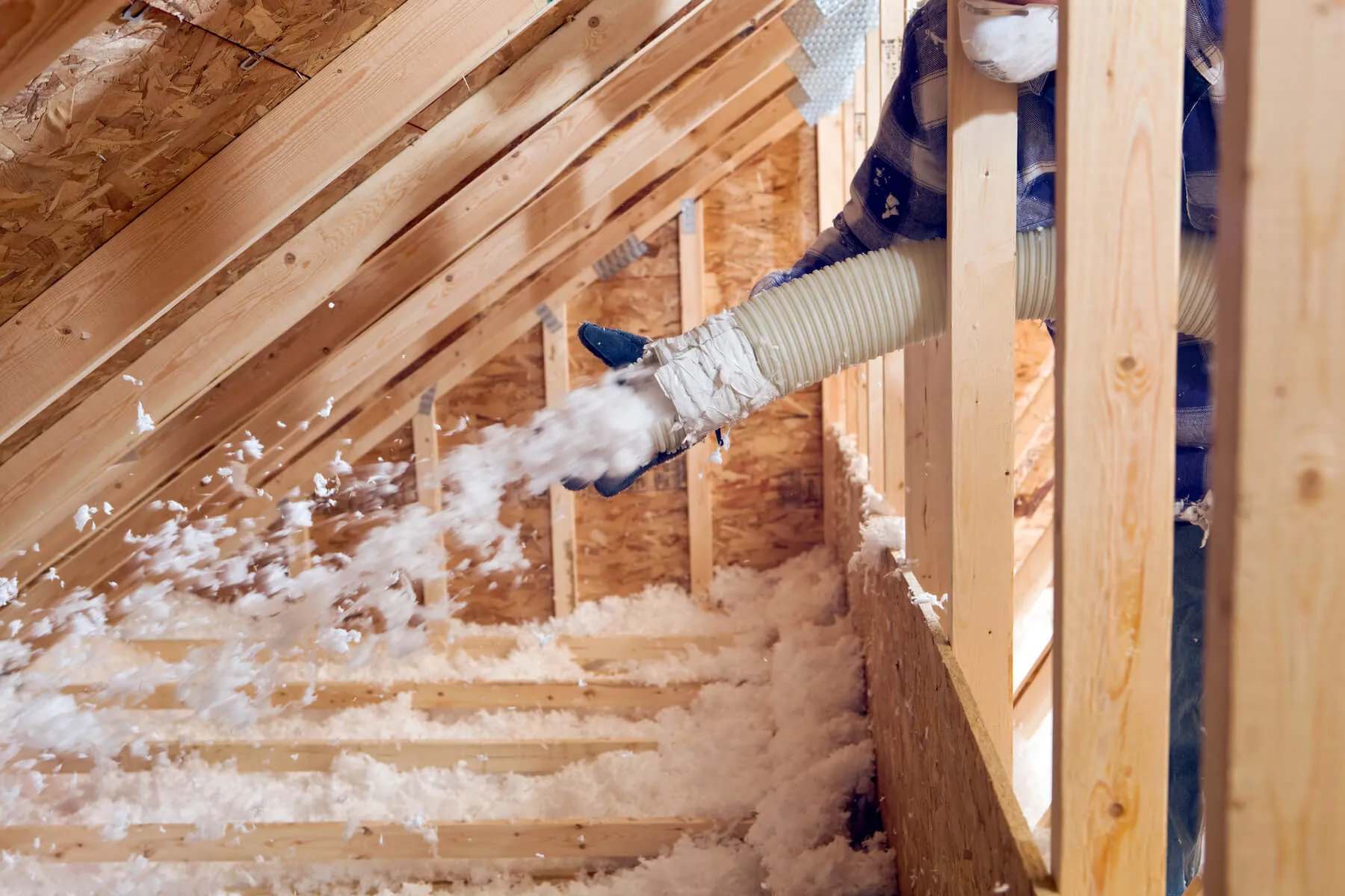 Installer applying spray foam with professional equipment